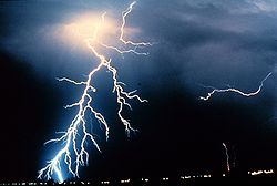 Lightning strikes during a night-time thunderstorm. When powerful electric currents flow through the Earth's atmosphere from the earth to the clouds, they change the air in their paths into plasma, radiating both sound (thunder) and bright light.