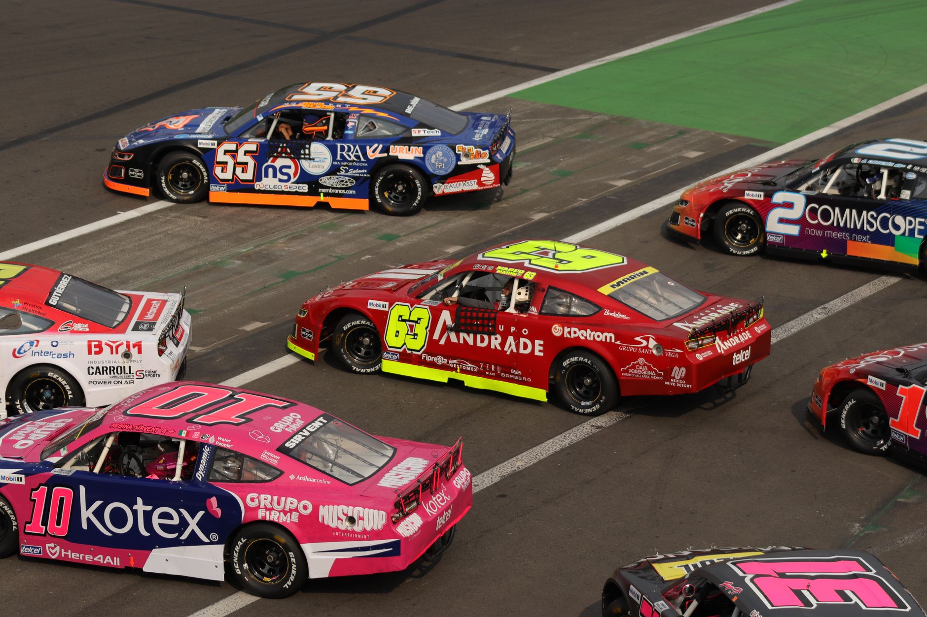 Stock cars running side by side at the start of a race