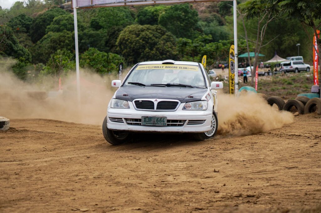 Dirt late model race car sliding through a clay corner
